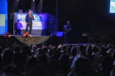 Comedian on stage in front of a large crowd