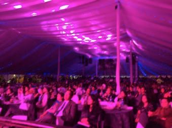 Audience in a lit marquee at a Ranee Productions event